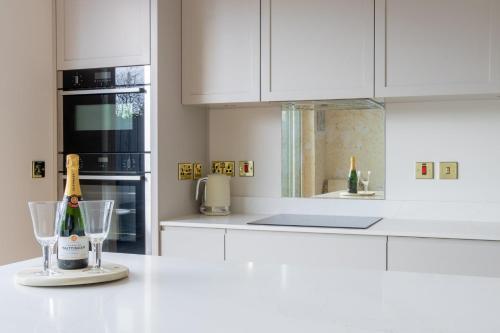 a white kitchen with a bottle of champagne and glasses at GuestReady - Amazing house in Sandymount in Dublin