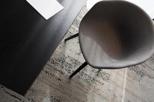 a black chair sitting next to a table at Toploft The Aparthotel in Crailsheim