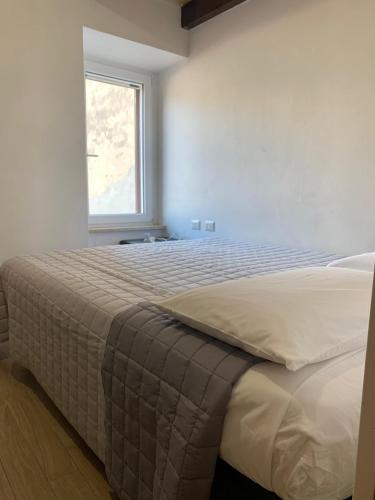 a bedroom with a large bed with a window at IL GINEPRO house in Cagliari