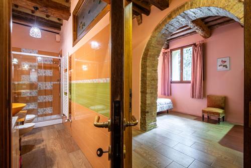 ein Bad mit ebenerdiger Dusche neben einer Tür in der Unterkunft La Torre di Monsindoli in Siena