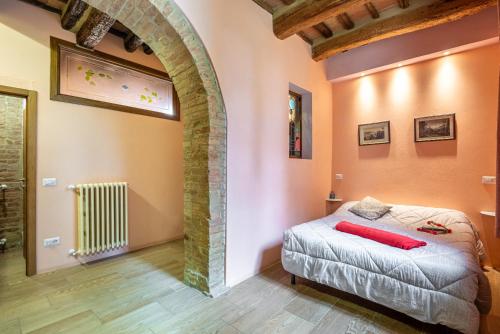 ein Schlafzimmer mit einem Bett in einem Zimmer mit einem Bogen in der Unterkunft La Torre di Monsindoli in Siena