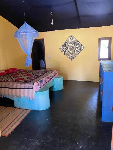a room with a bed and a wall with paintings at MKS - Kite & Wing Foil camp in Kalpitiya
