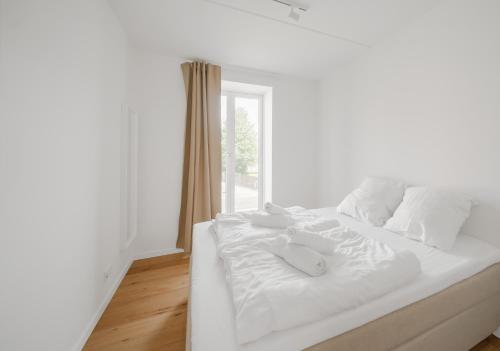 a white bed with white sheets and a window at Fantastic 2-bed apartment with balcony in Odense