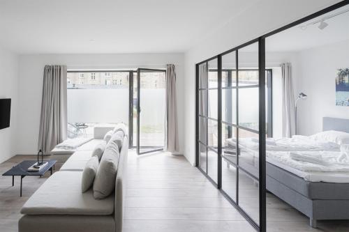 a white bedroom with a bed and a couch at Fantastic 1-bed apartment w private terrace in Aarhus