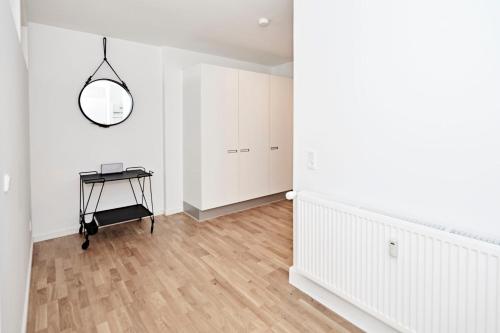 an empty white room with a table and a mirror at Cool 1-bed with private terrace in Copenhagen