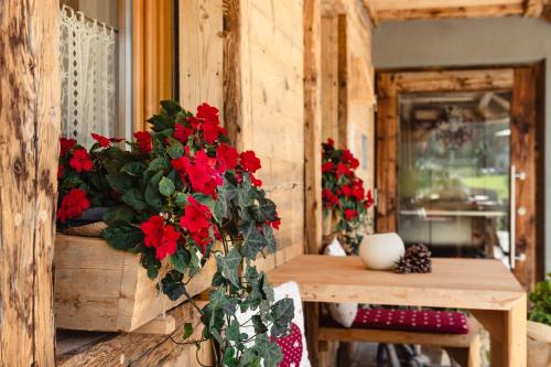 Un mazzo di fiori rossi in un vaso su un tavolo di Residence Corn Le Ciastel a San Vigilio Di Marebbe
