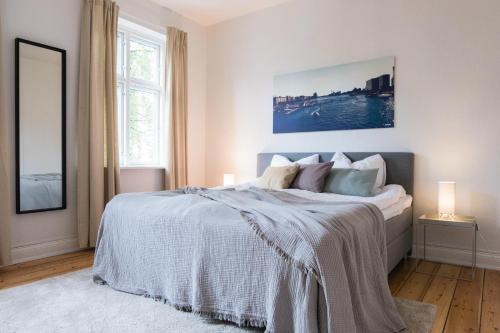 Beautiful 2-bed in great location في أُرهوس: غرفة نوم بسرير ابيض كبير ومصباحين