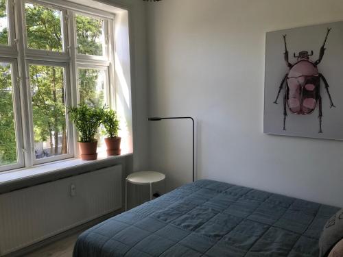 a bedroom with a bed and a picture of a beetle on the wall at Great 1-bed in Østerbro - 309 in Copenhagen