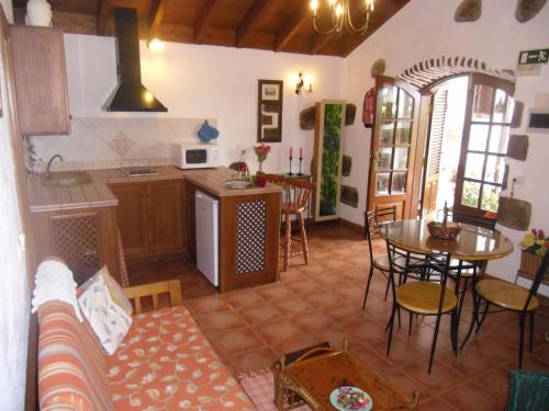 Your Island Finca El Picacho C في Tegueste: مطبخ وغرفة معيشة مع أريكة وطاولة