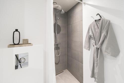 a bathroom with a shower and a robe on a rack at Private Townhouse w terrace in Aarhus