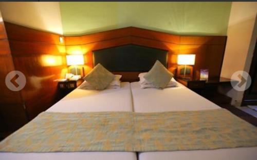 ein Schlafzimmer mit einem großen weißen Bett mit zwei Lampen in der Unterkunft Hotel Vip International in Kalkutta