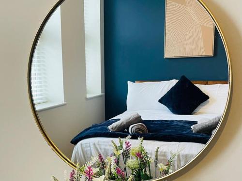 a mirror reflecting a bed in a room with a bed sqor at Brantwood Apartments - Apartment 2 in Manchester