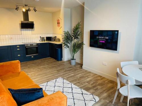 a living room with a couch and a table and a kitchen at Brantwood Apartments - Apartment 2 in Manchester