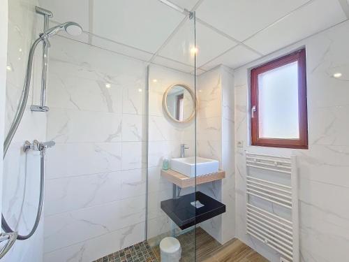 une salle de bain blanche avec une douche et un lavabo dans l'établissement Hameau de Gîtes de St-Victor-en-Marche, à Bussière