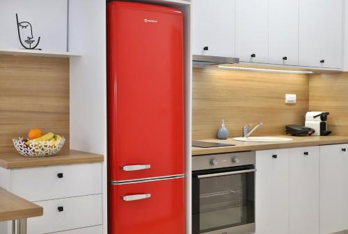 a red refrigerator in a kitchen next to a sink at Centro Apartments by Comfortbnb- Sitia in Sitia
