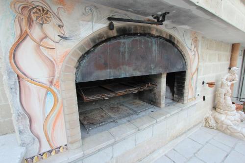 a stone fireplace with a horse painted on it at Residence Borgo Antico in Diso