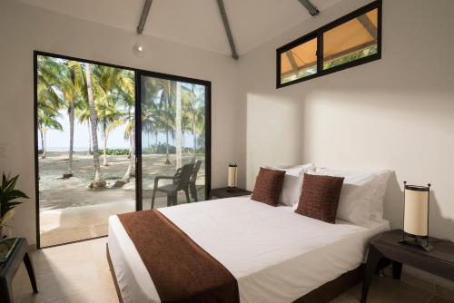 a bedroom with a bed with a view of the beach at Tayrona Tented Lodge in Guachaca