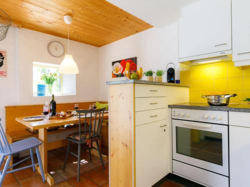 una cucina con tavolo e una cucina con piastrelle gialle di Apartment Villaggio Sureggio - App- A7 by Interhome a Lugaggia