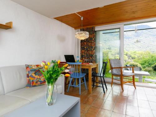 un soggiorno con divano, tavolo e sedie di Apartment Villaggio Sureggio - App- A7 by Interhome a Lugaggia