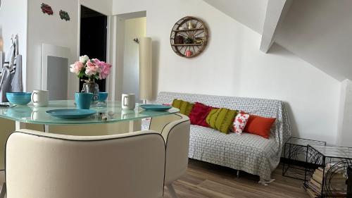 une salle à manger avec une table et un canapé dans l'établissement La little white house, à Cayeux-sur-Mer