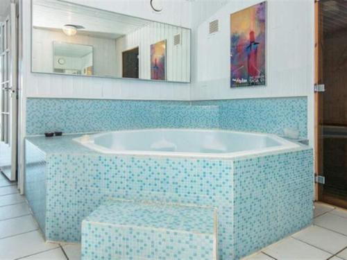 y baño con bañera y suelo de baldosa azul. en Holiday Home Herma - all inclusive - 1km from the sea by Interhome en Fanø