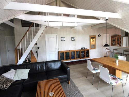 a living room with a black leather couch and a table at Holiday Home Herma - all inclusive - 1km from the sea by Interhome in Fanø