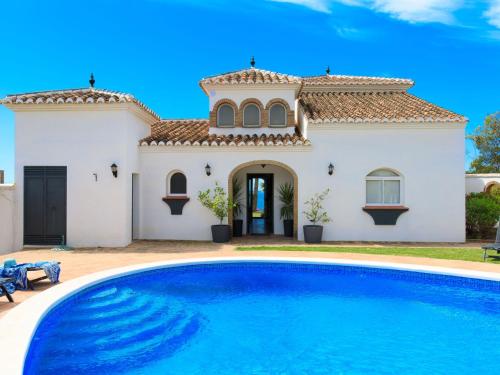 a villa with a swimming pool in front of a house at Villa Atardecer by Interhome in Torrox Costa