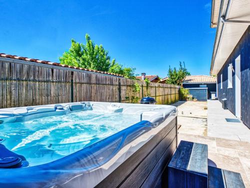una bañera de hidromasaje en un patio trasero con una valla en Villa Plein Air by Interhome, en Gujan-Mestras