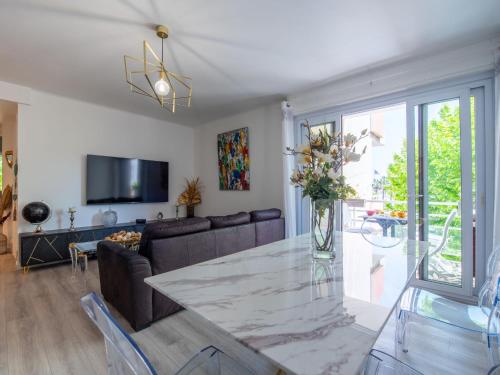 un salon avec une table avec un vase de fleurs dans l'établissement Apartment Les Hesperides-3 by Interhome, à Cavalaire-sur-Mer
