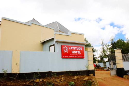 a building with a sign for a hotel at Latitude Lukozi Hotel in Hambayo