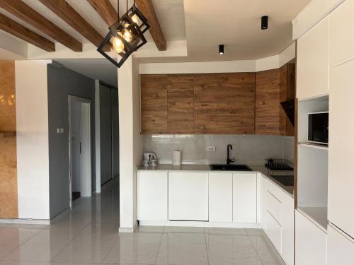 cocina con armarios blancos y techo en Old Town Square Apartment, en Skopje