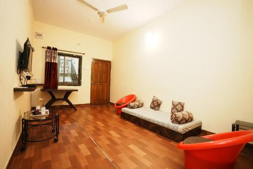 uma sala de estar com um sofá e uma mesa em Springfield Family Apartment em Mahabaleshwar