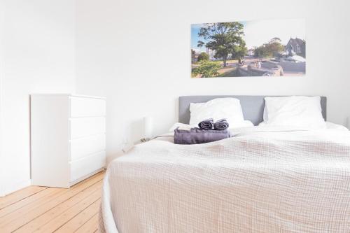 1 dormitorio con 1 cama grande con sábanas blancas en Spacious and cool 1-bed in Øgadekvarteret en Aarhus