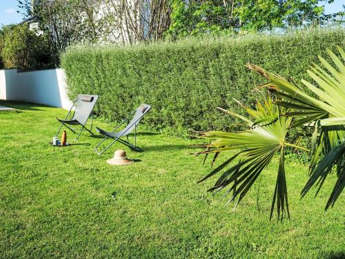deux chaises assises dans l'herbe dans une cour dans l'établissement Holiday Home Ty Maez by Interhome, à Plonéour-Lanvern