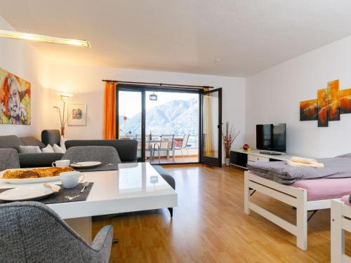 a living room with a couch and a table at Apartment Residence Miralago - Utoring Apt- D32 by Interhome in Piazzogna