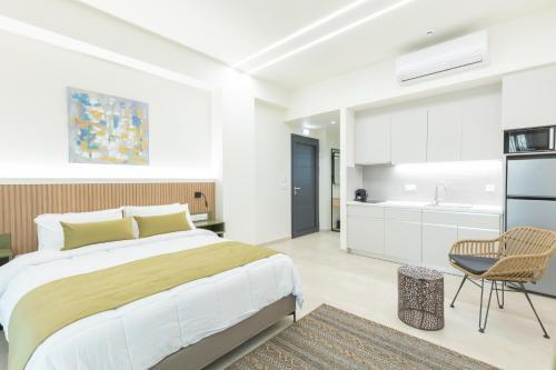a bedroom with a large bed and a kitchen at Nostos Suites in Kourouta