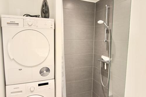 a bathroom with a walk in shower and a mirror at Fantastic 1-bed w balcony in Ørestaden in Copenhagen