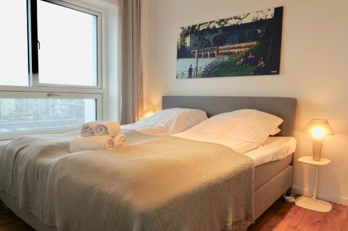 a bedroom with a bed with two towels on it at Stunning 2-bed wbalconies and great views in Copenhagen