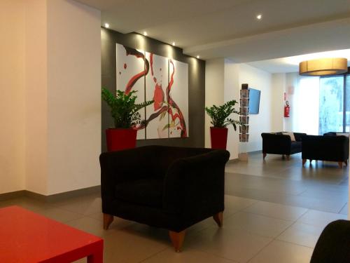 a living room with a black chair and potted plants at Toscana Ambassador in Poggibonsi