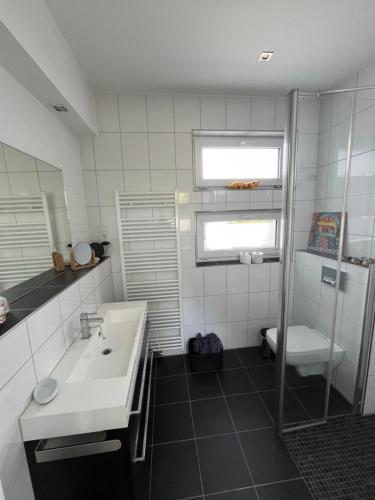 La salle de bains blanche est pourvue d'un lavabo et de toilettes. dans l'établissement Marys Guestroom, à Goch