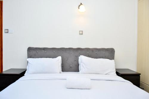 a bedroom with a large bed with white sheets and pillows at The Wills 3 Bedroom Apartment in Nairobi in Nairobi