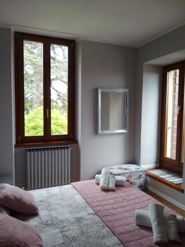 a bedroom with two beds and two windows at Casa Gabry Bouganville in Toscolano Maderno