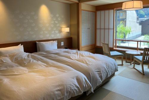 Postel nebo postele na pokoji v ubytování Akaishiya 城崎温泉旅館 赤石屋