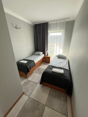 a small room with two beds and a window at Gościniec Wigry 1 in Walne