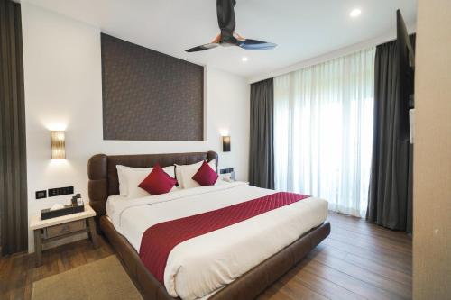 a bedroom with a large bed with red pillows at Classic Regency in Alleppey