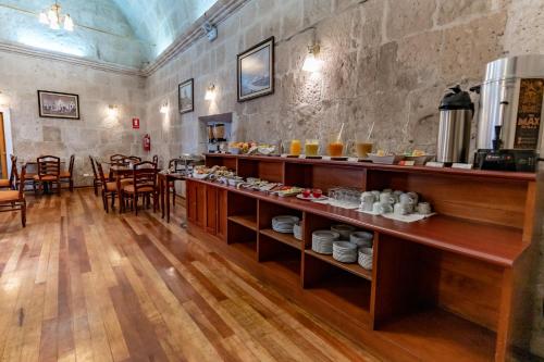 un restaurante con una barra larga con comida. en Casona Terrace Hotel, en Arequipa