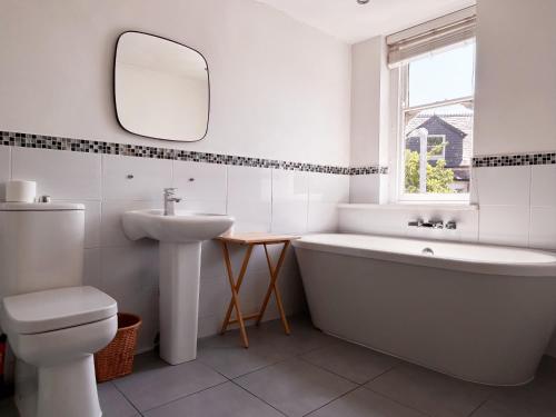 a bathroom with a tub and a sink and a mirror at Cardiff Victorian House Sleeps 6 in Roath 15mn City centre in Cardiff