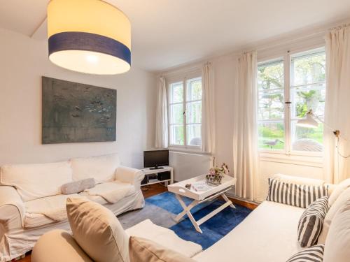 una sala de estar con muebles y ventanas blancos. en Apartment Gut Hörne-2 by Interhome, en Hörne