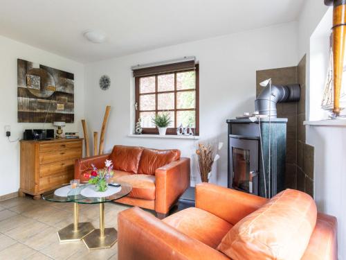 a living room with leather furniture and a fireplace at Chalet Nachtigall by Interhome in Osten