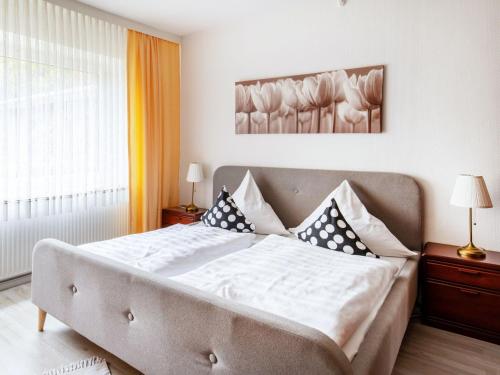 Apartment Waldblick-2 by Interhome في Armstorf: غرفة نوم بسرير كبير عليها شراشف ووسائد بيضاء